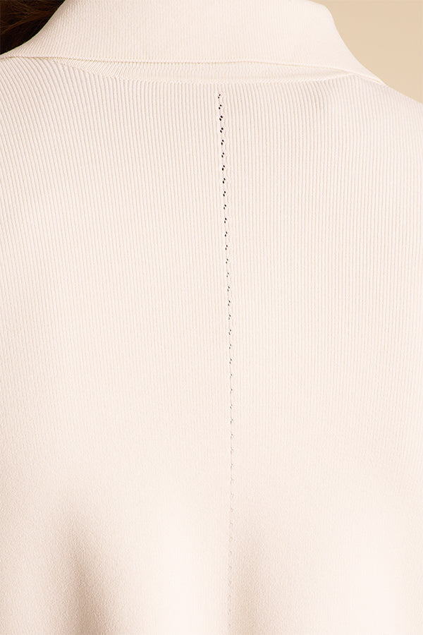 Woman wearing a white blazer over a black dress on a beige background | Exclude | Grid Hover