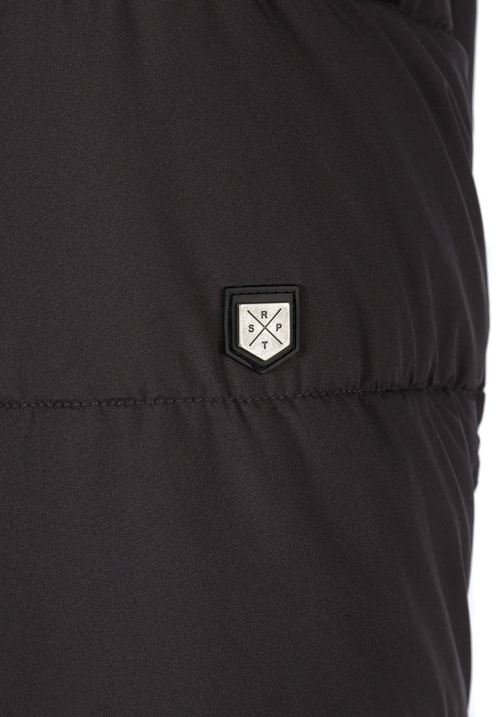 Detail of a men's long jacket featuring a logo badge.