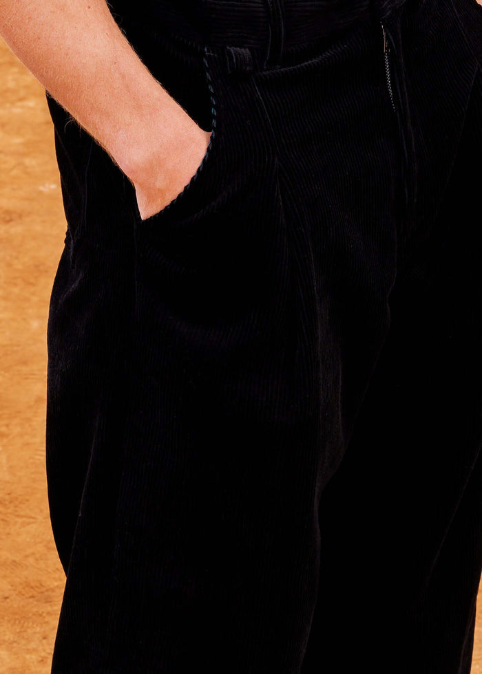 Close-up of Pleated Corduroy Trousers showing relaxed fit and deep pockets on a model.