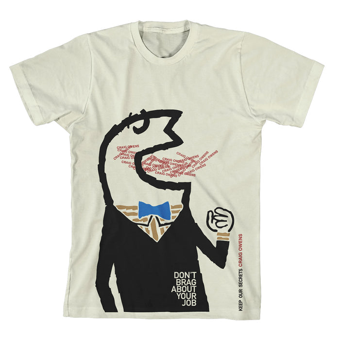 A Craig Owens white t-shirt featuring a suited figure eating the words CHAIN GEMS repeatedly, with DONT BRAG ABOUT YOUR JOB printed below. The figure sports a blue bow tie and a tan collar.