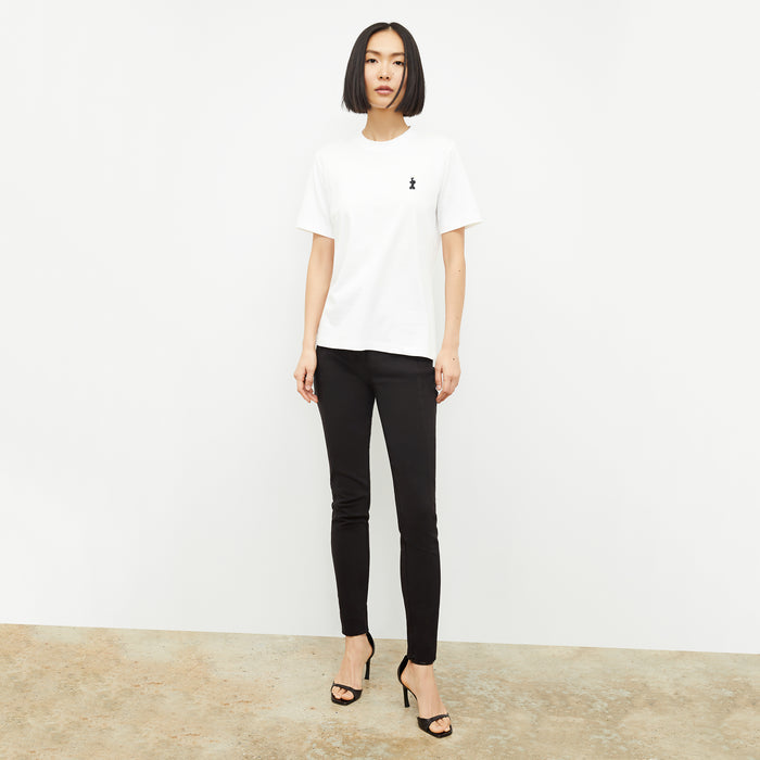 front image of a woman wearing the leslie t-shirt embroidered in white