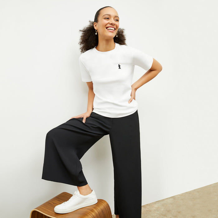front image of a woman wearing the leslie t-shirt embroidered in white