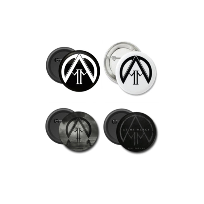 Set of four round At My Mercy buttons featuring the stylized AM logo in black on white, white on black, black on gray, and black on a grayscale background with subtle text.