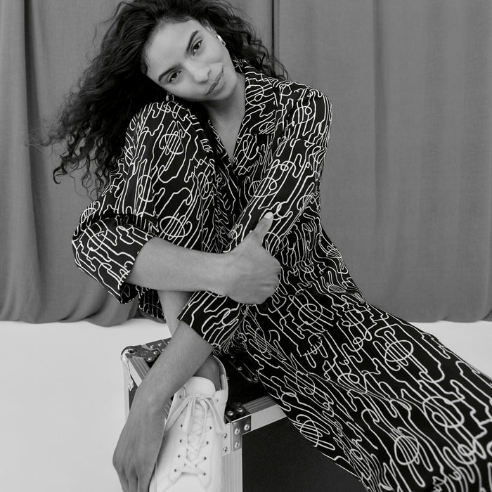 image of a woman sitting wearing the alyssa jacket in symphony print | ALT GRID