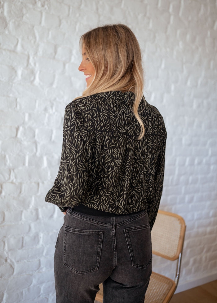 Front view of black and green leaf-print shirt
