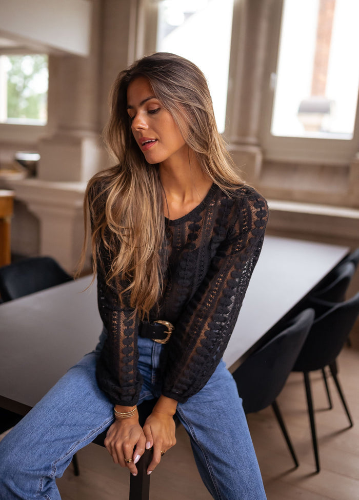 Woman wearing black lace blouse with jeans