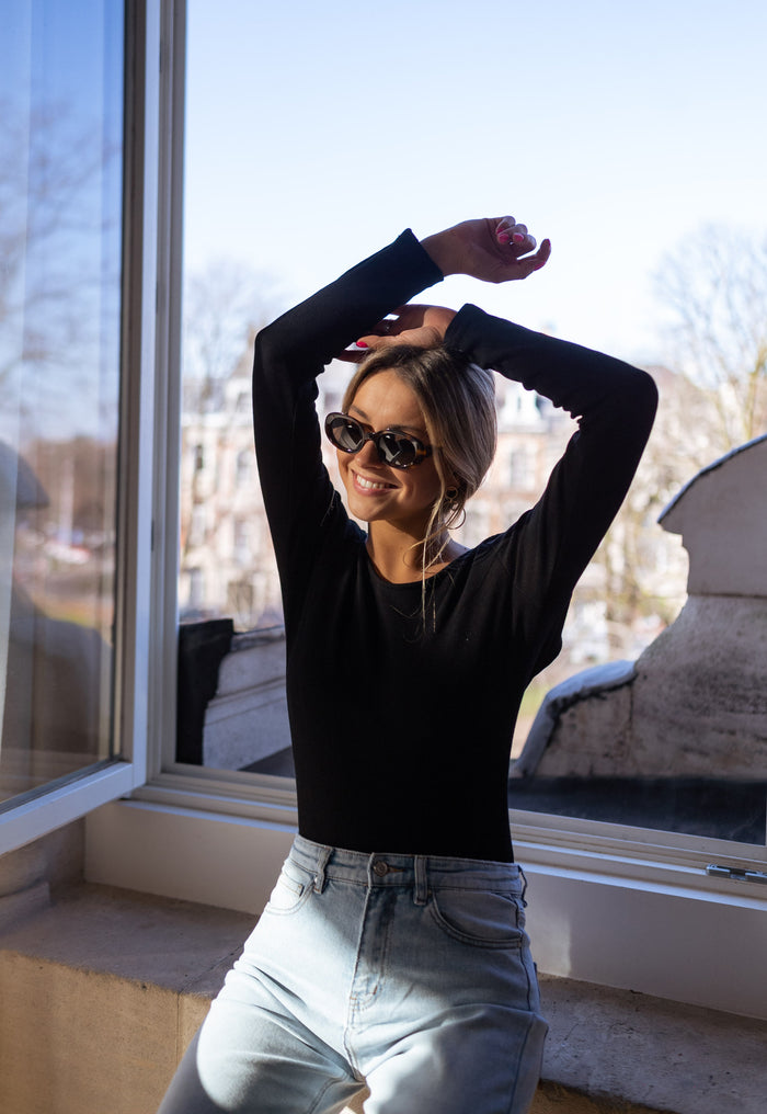 Model wearing black Yael open-back bodysuit
