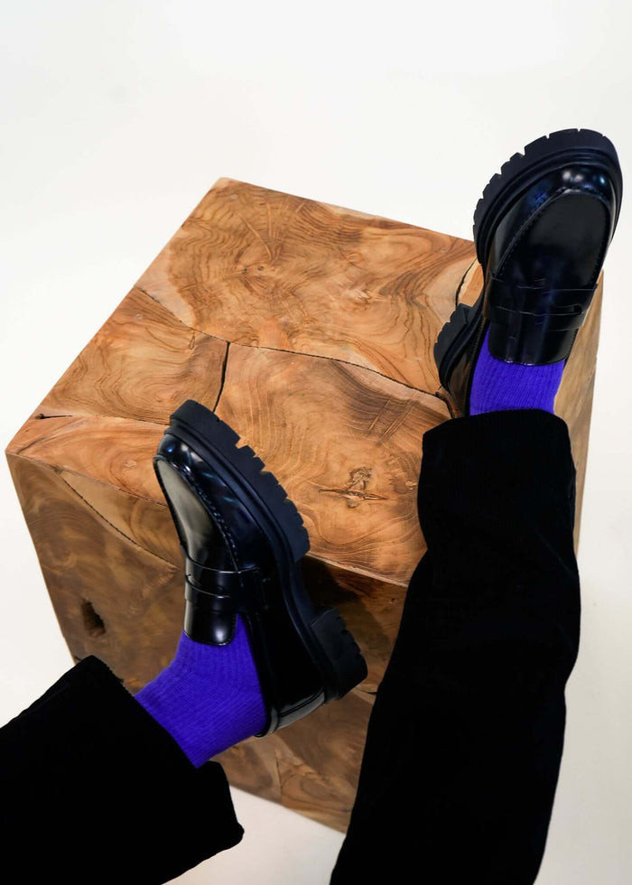 Blue crew socks in Surf The Web shade worn with loafers on stool