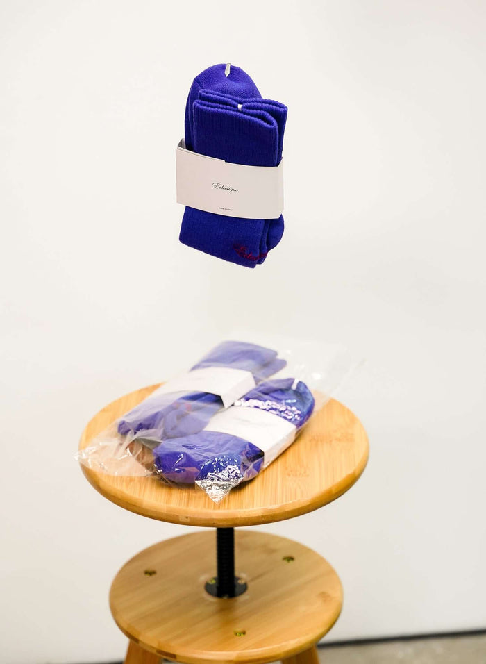 Blue Crew socks floating in the air above stool