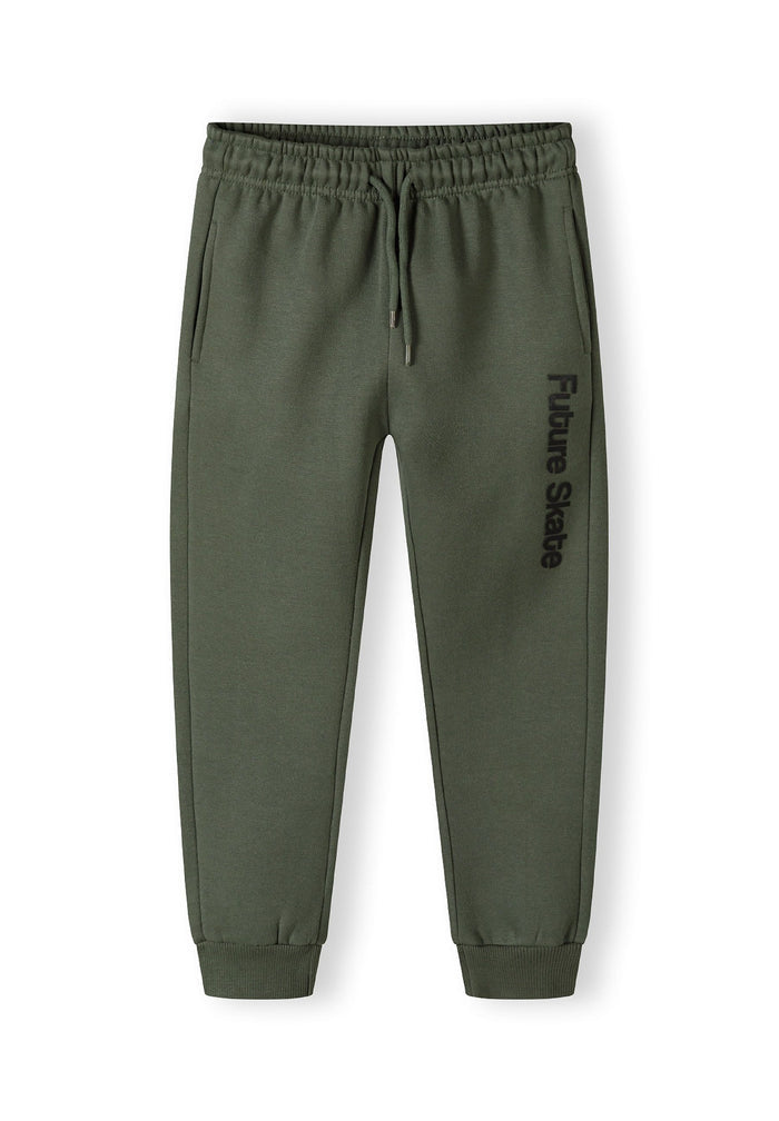 Detail of khaki jogger pants with 'Future Skate' print and ribbed ankle cuffs.