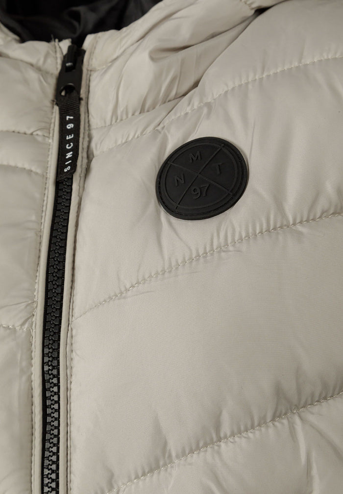 Detail of boys gilet with fixed hood, full-length zip, and chest badge.