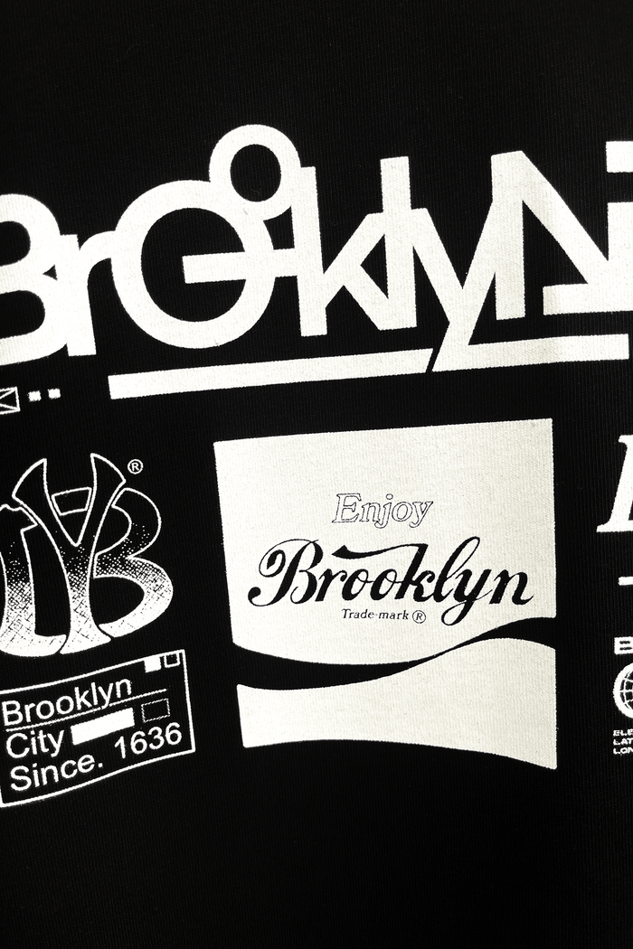 Brooklyn graphic t-shirt with white printed artwork on black fabric featuring various logos and designs.