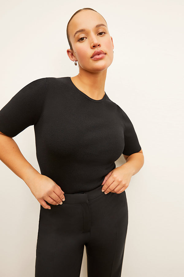 Front image of a woman standing wearing the Choe Top in Black | Exclude