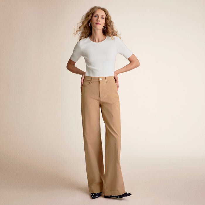 Front image of a woman standing wearing the choe top in ivory