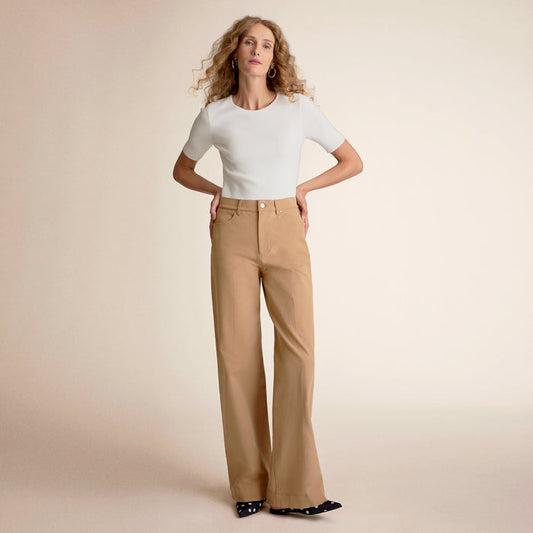 Front image of a woman standing wearing the choe top in ivory