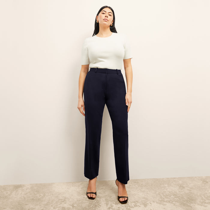 Front image of a woman standing wearing the choe top in ivory