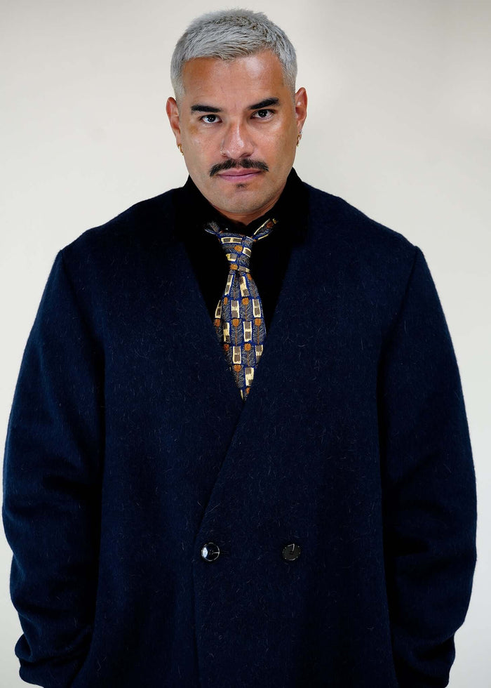 Éclectique collarless long coat in navy styled with shirt and tie front portrait view