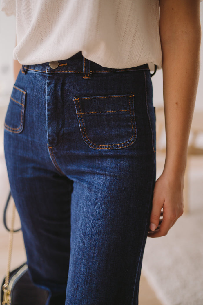 Model wearing dark blue Hugues flared jeans