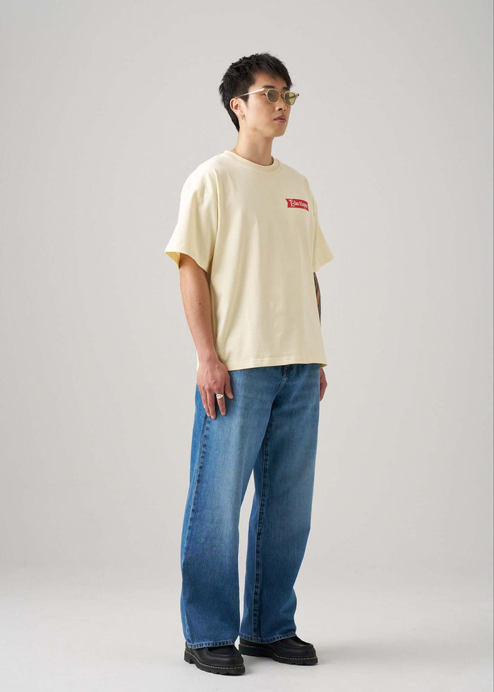 Model wearing a relaxed boxy fit Cream graphic T-shirt in French Vanilla color with printed Date Night artwork.