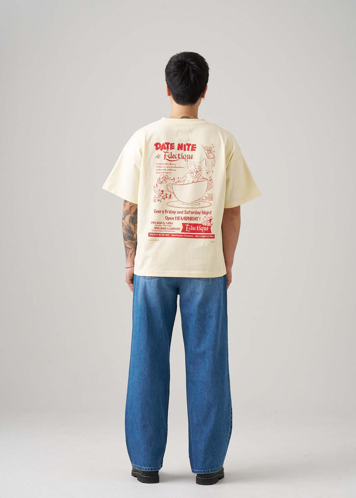 Back view of a model wearing a cream graphic T-shirt with Date Night artwork by Éclectique, relaxed fit and oversized style.