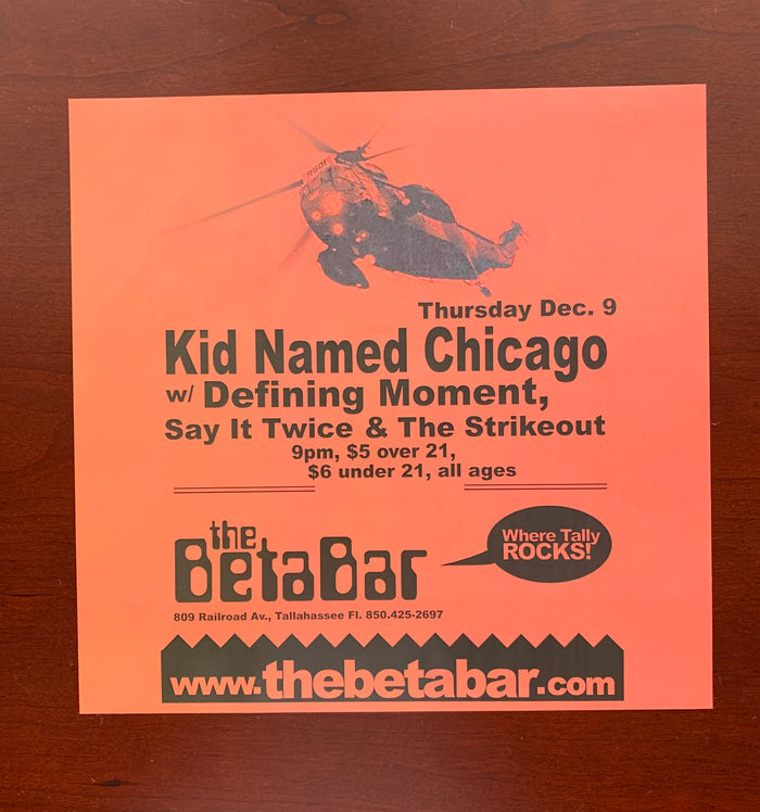 An orange DZRP flyer on a wooden surface advertises a concert at The Beta Bar with Kid Named Chicago. Event details and a graphic of a helicopter over rocks are in the top left corner, highlighting the Tallahassee music scene.
