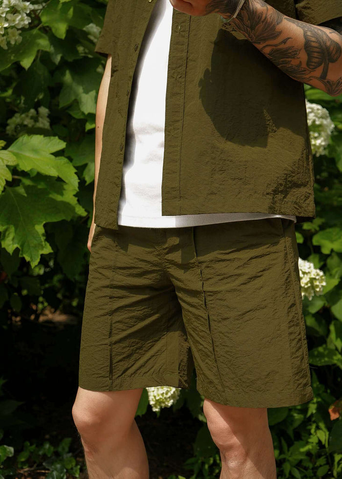 Men's casual shorts in olive green, paired with a matching shirt, perfect for stylish summer outings.