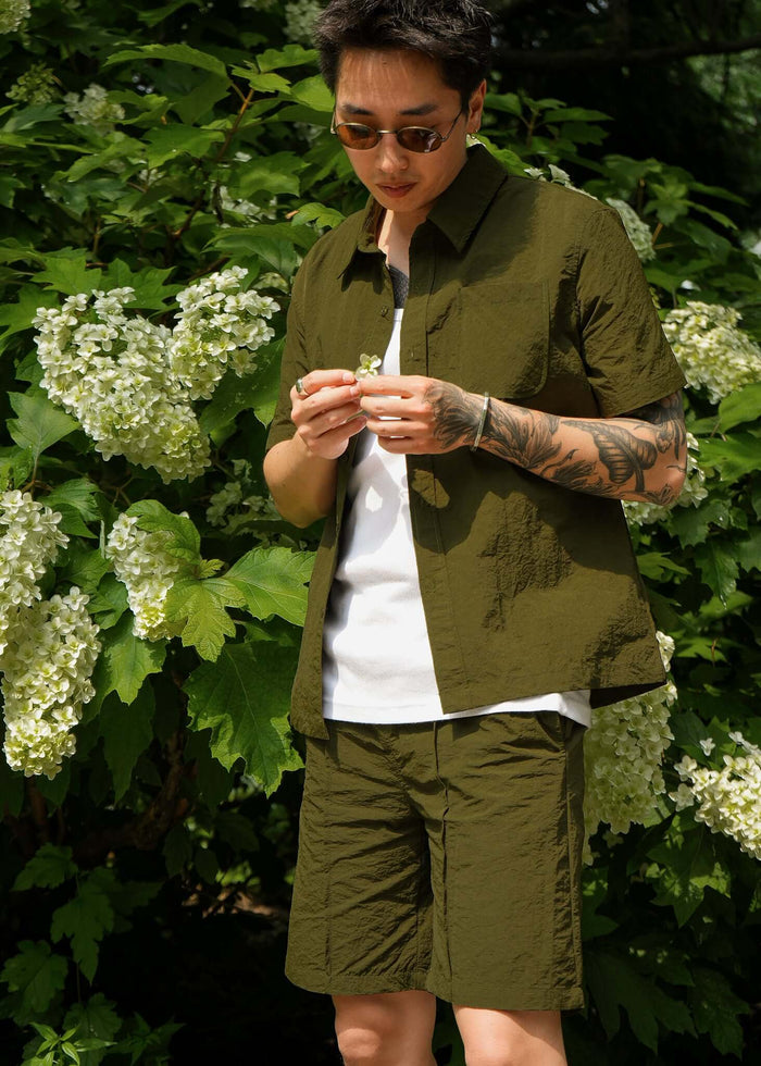 Men's casual shorts in olive green, featuring a slim fit and lightweight design, paired with a matching shirt.