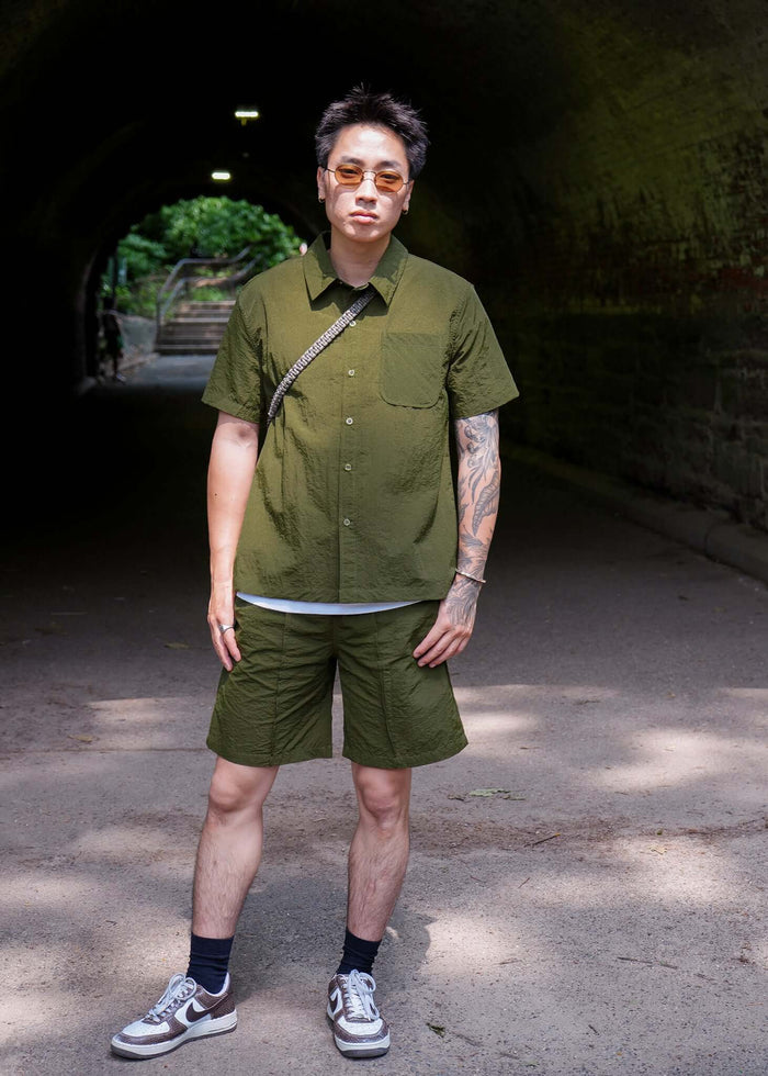Designer Short sleeve casual shirt displayed on a model in an outdoor setting, showcasing a stylish olive green design.