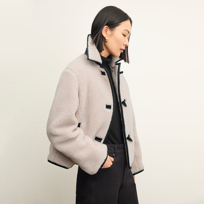 side image of a woman wearing the eli jacket in travertine