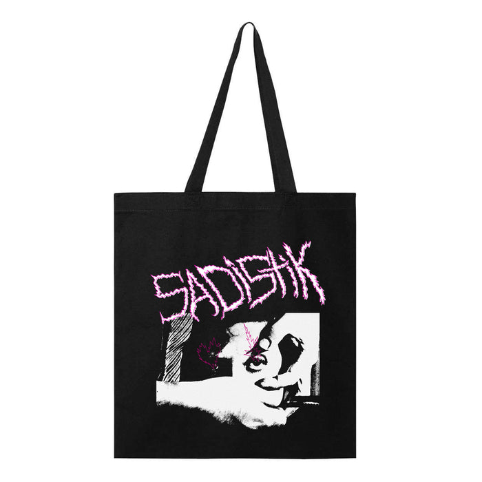 A black Sadistik tote bag with SADISH in jagged pink letters at the top and an abstract black-and-white graphic illustration below.