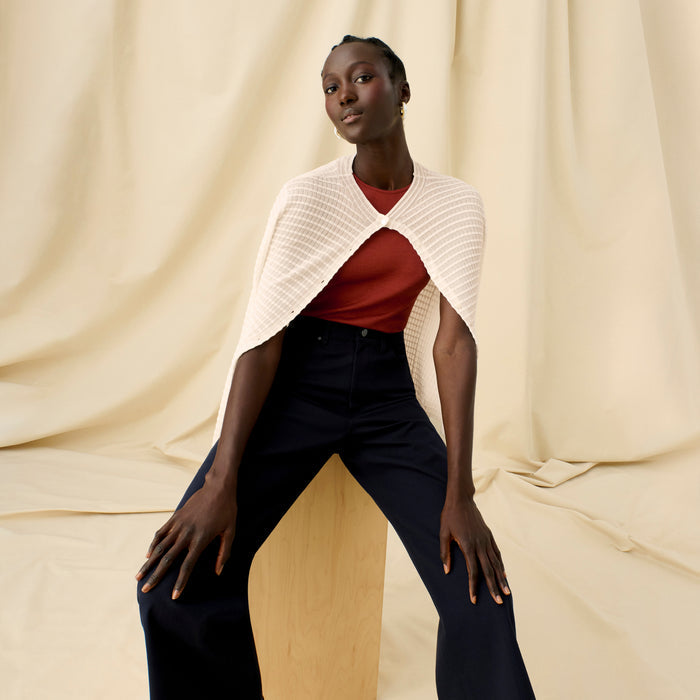 Front image of a woman sitting wearing the Emerson Cardigan in Meringue