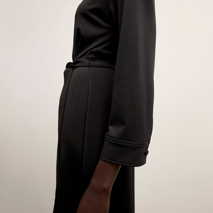 side image of a woman wearing the emmett dress in black