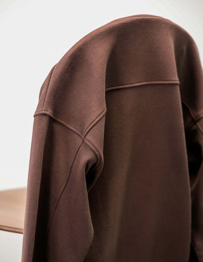 French Terry crewneck sweatshirt displayed on a chair, highlighting its soft fabric and minimalist design.