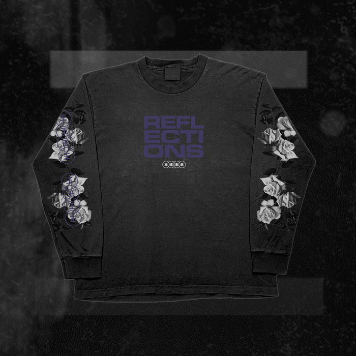 A black Reflections long sleeve shirt with bold purple REFLECTIONS lettering on the chest and white roses down each sleeve, made from 100% cotton, shown on a dark textured background.