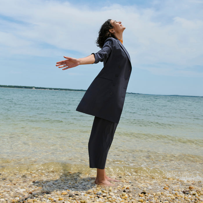 side image of a woman on the beach wearing the gwynne dress in cool charcoal