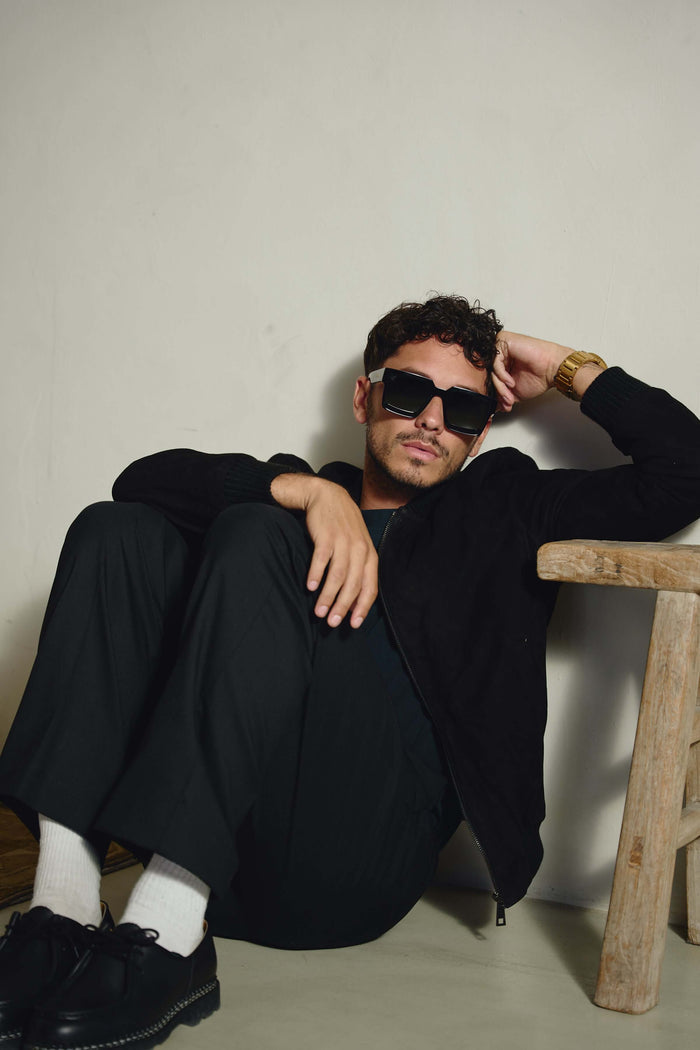Model sitting in black Italian suede bomber jacket by Éclectique