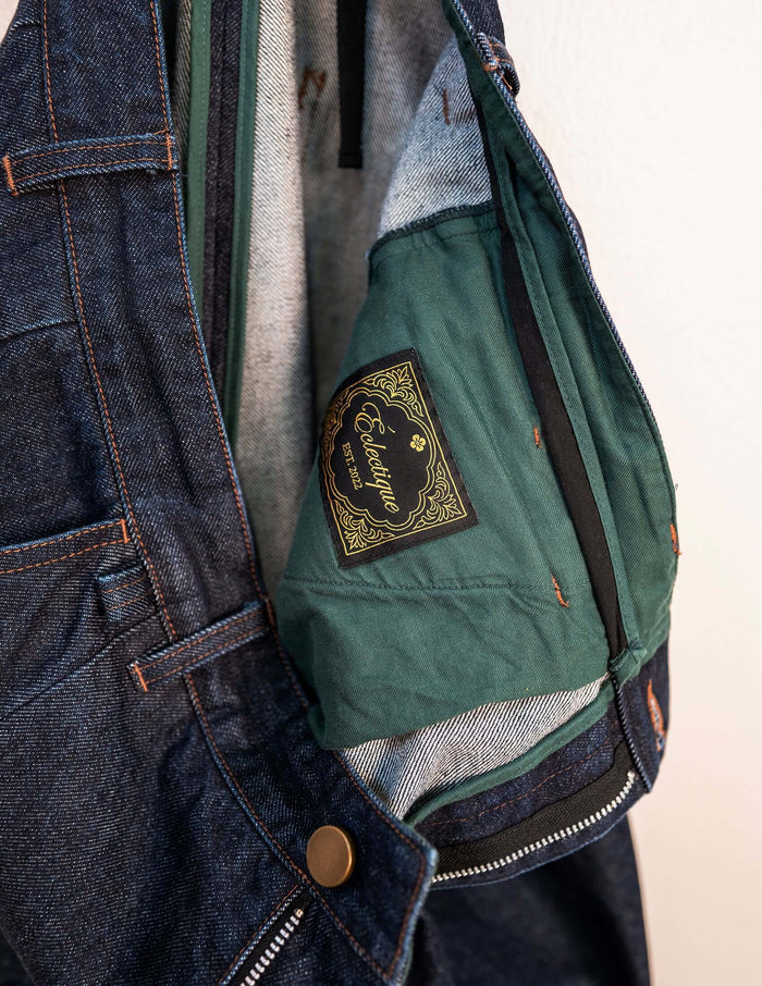 Kura Indigo Jeans interior showing green fabric lining and label with intricate design.