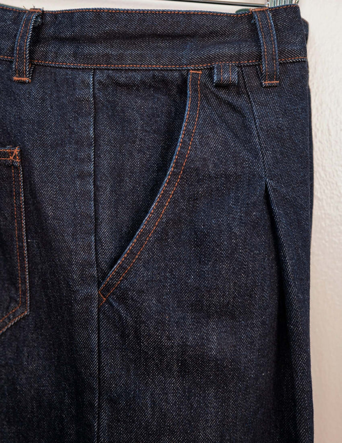 Close-up of Kura Indigo Jeans showing angled front pockets and sharp pleats in raw indigo denim.
