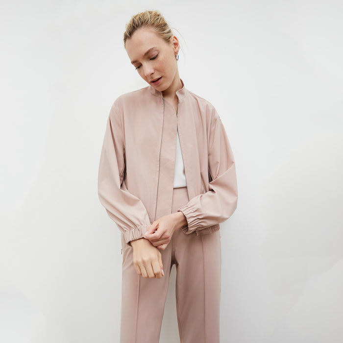 Front image of a woman wearing the Langely Bomber in Origamitech in Blush