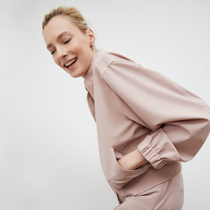 Front image of a woman wearing the Langely Bomber in Origamitech in Blush