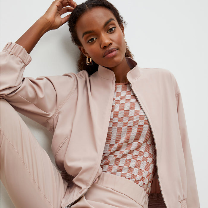 Front image of a woman wearing the Langely Bomber in Origamitech in Blush