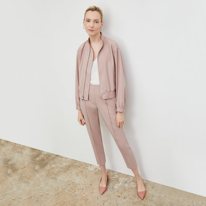 Front image of a woman wearing the Langely Bomber in Origamitech in Blush