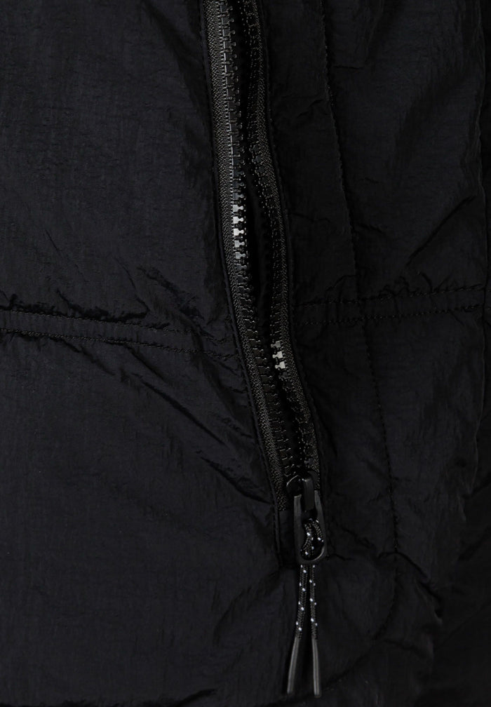 Detail of a black quilted boys jacket featuring a zip pocket.