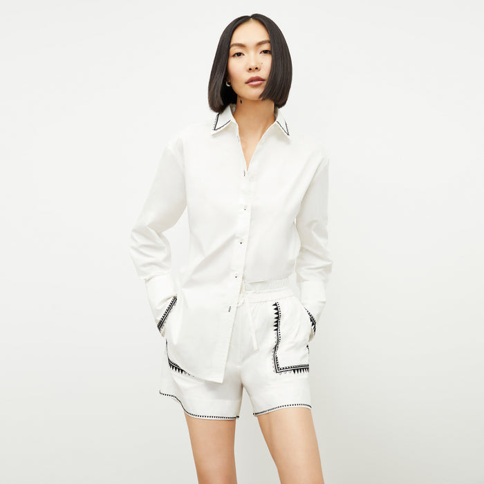 front image of a woman wearing the mila button down in white | Lead