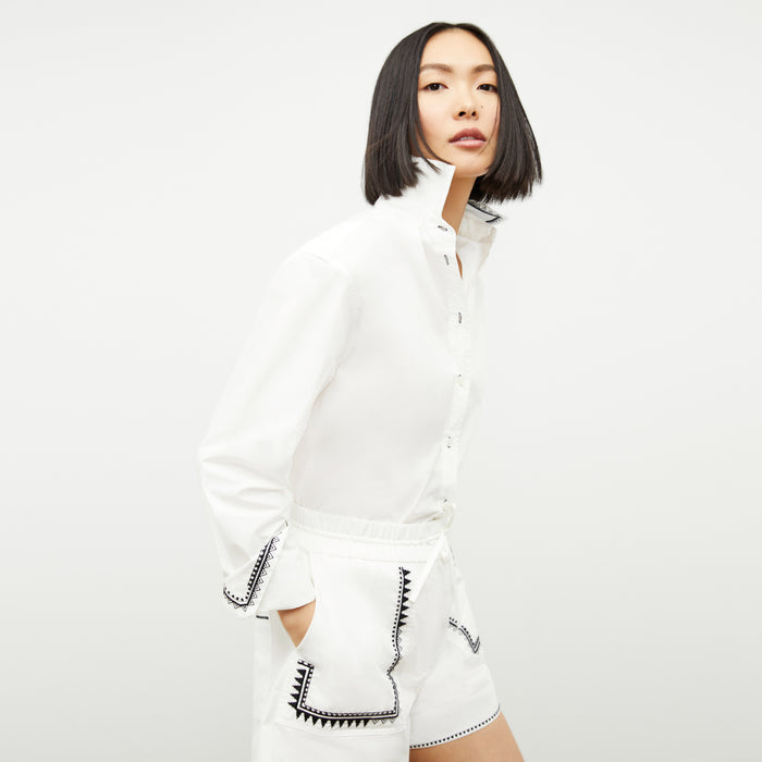 front image of a woman wearing the mila button down in white