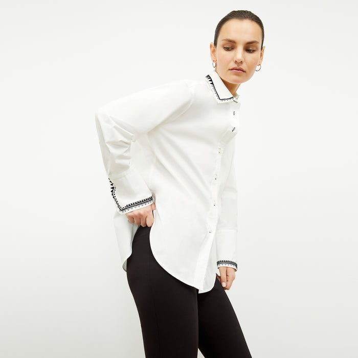 front image of a woman wearing the mila button down in white