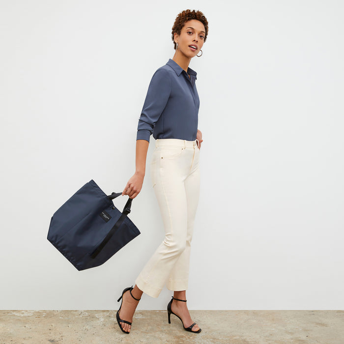Side image of a woman wearing the Bags in Progress x MM Carry All Tote  in Navy