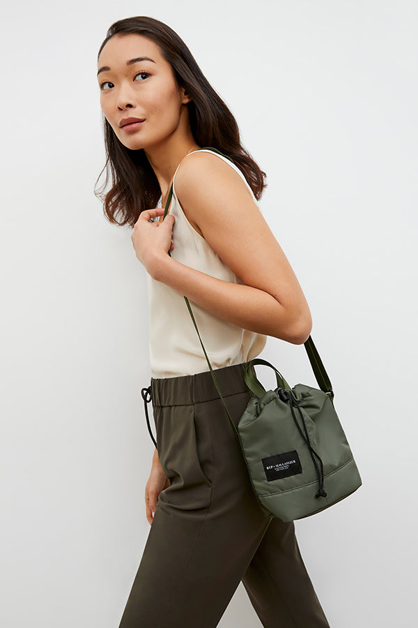 Front image of a woman wearing the Bags in Progress x MM Padded Mini Bucket Bag in Khaki Green | Grid Hover | Exclude