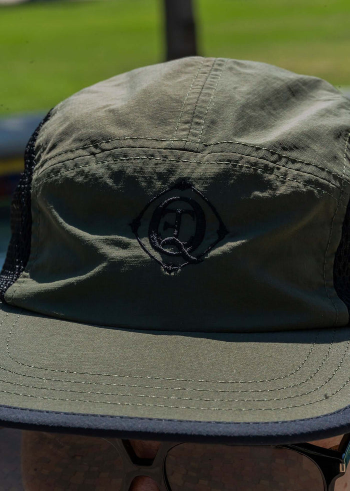 Monogram Performance Mesh Cap Olive showcasing a black logo on olive ripstop fabric with breathable mesh panels.