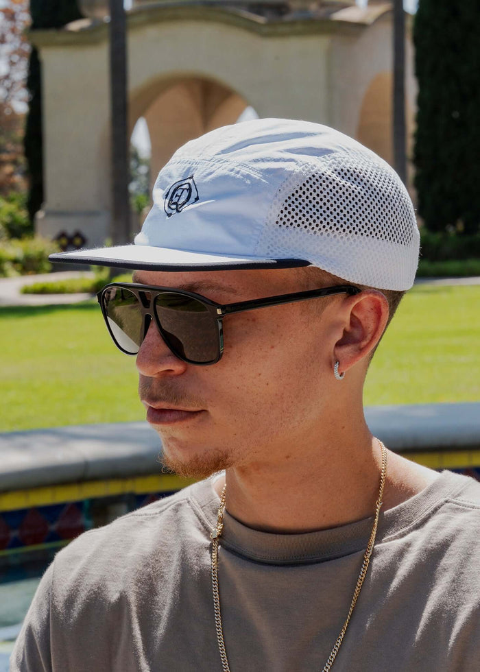 Monogram Performance Mesh Cap White worn by a man with sunglasses, featuring breathable mesh panels and signature logo.